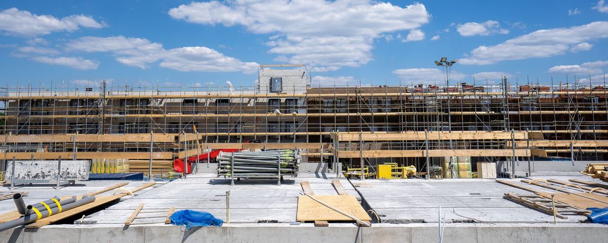 Concrete frame with edge protection and scaffolding on a residential block under construction