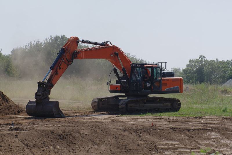Tracked excavator stripping topsoil on a greenfield site