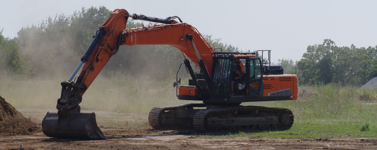 Tracked excavator stripping topsoil on a greenfield site